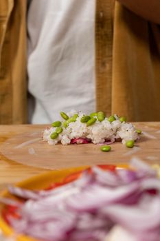 Close-up of fresh spring roll preparation featuring rice and edamame on a wooden surface.