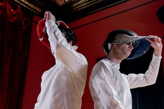 Two Men Removing Epee Mask
