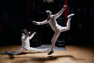 Two Men In Fencing Suits and Practicing With Swords