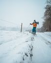 Man in Red Jacket and Black Pants Riding Ski Blades on Snow Covered Ground