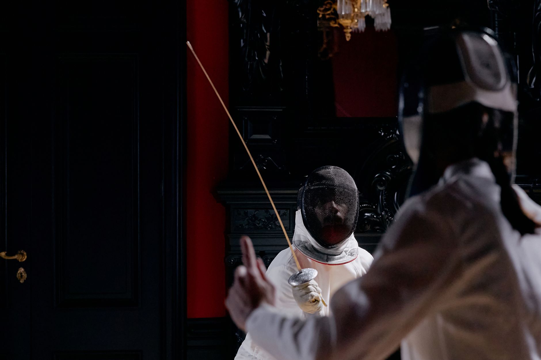 Two athletes engage in a dynamic fencing match, showcasing skill and precision.