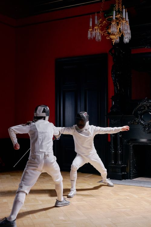 Free Two fencers engaged in a dynamic duel indoors, showcasing skill and agility. Stock Photo