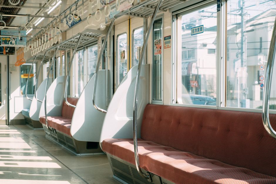 Interior of spacious empty wagon of modern train with soft seats and metal handrails in modern city