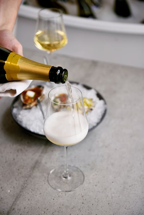 A Person Pouring Champagne in a Glass