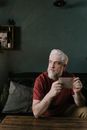 Man in Red Crew Neck T-shirt Sitting on Black Sofa