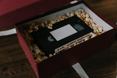 Popcorn and a VHS Tape Inside a Cardboard Box