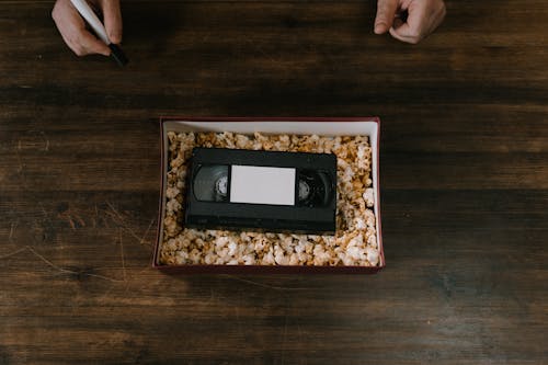 Popcorn and a Vhs Tape Inside a Cardboard Box