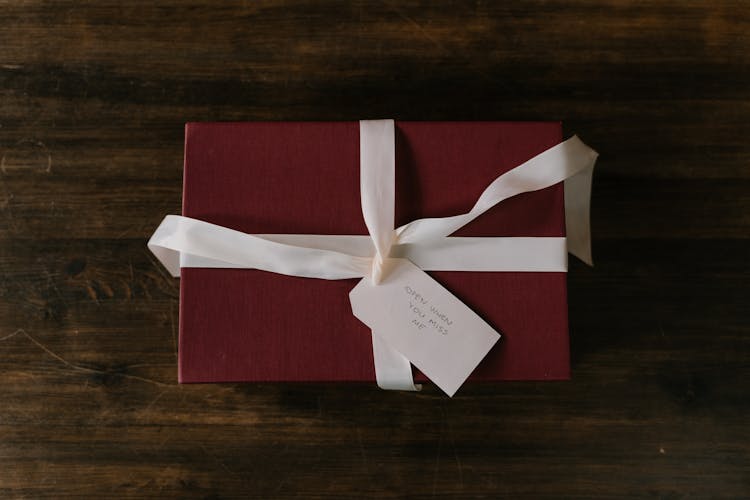 Box With White Ribbon On A Wooden Surface