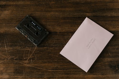 A Cassette Tape Beside a Paper with Handwritten Words