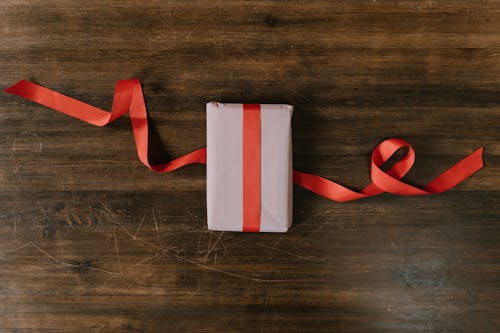 Free A Gift in a Wrapping Paper and Red Ribbon Stock Photo