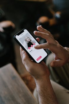 Close-up of hands using a dating app on a smartphone indoors. Modern technology and online dating.
