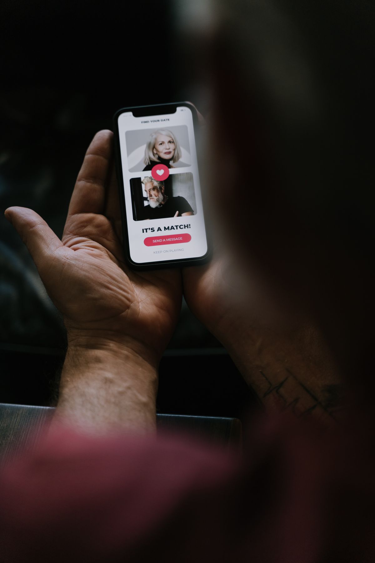 Hands holding a phone with a dating app screen