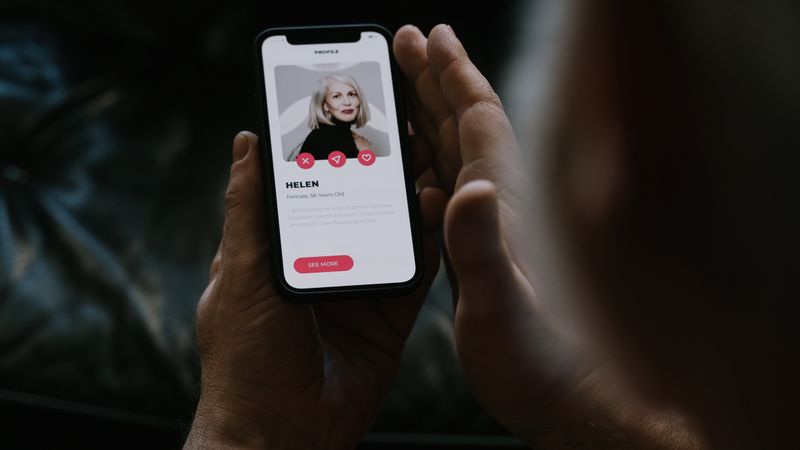 Person using a mobile dating app, highlighting smartphone technology and online connections.
