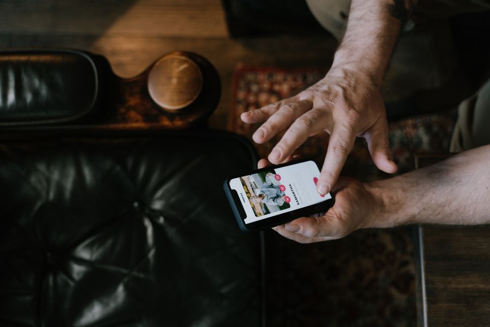 Overhead view of a man using a dating app on his phone