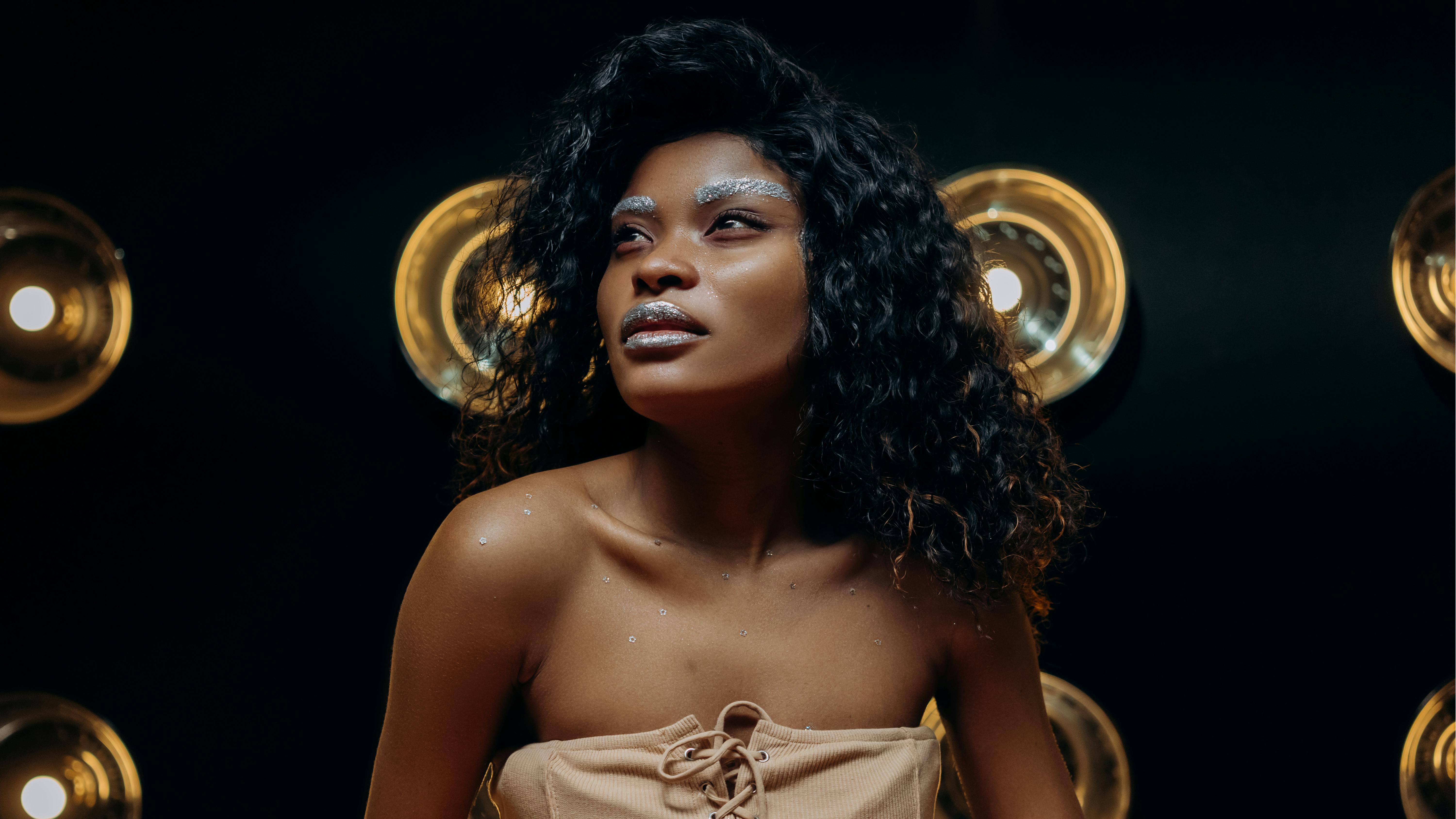 优雅的黑人女性肖像，妆容闪亮，在工作室环境中展示时尚和风格