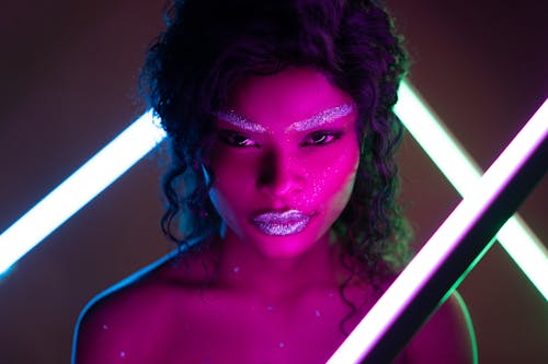 Woman's Face in Glitter Makeup with Purple Light Reflection