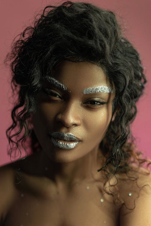 Woman with Curly Hair Wearing Glitter Makeup on Eyebrows and Lips