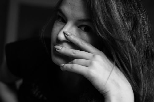 Free Black and white portrait of a woman with her hand near her face, conveying emotion. Stock Photo