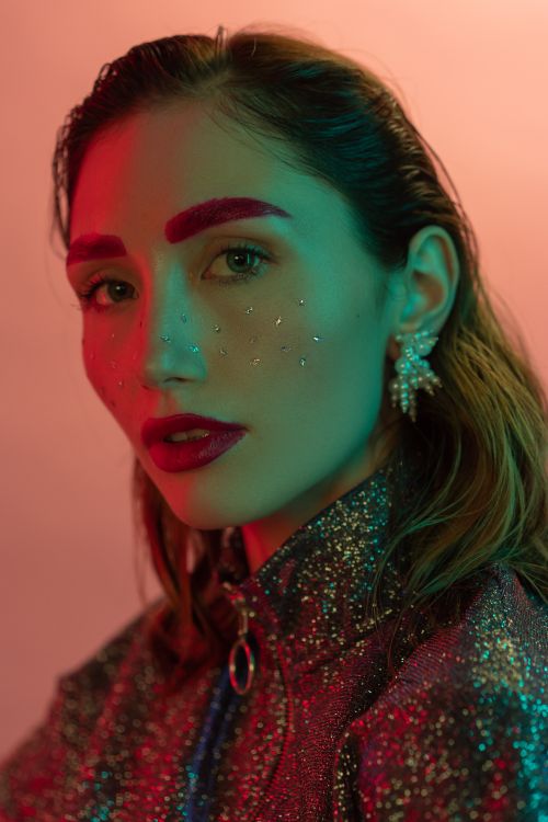 Free Vibrant close-up portrait of a woman with artistic makeup and jewelry. Stock Photo