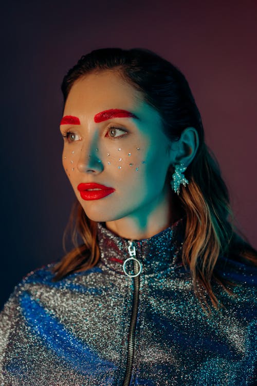 Close Up Photo of Woman with Red Eyebrows and Lipstick and Glitters on Face