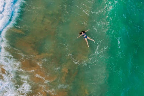 Woman in Blue Bikini Floating on the Sea