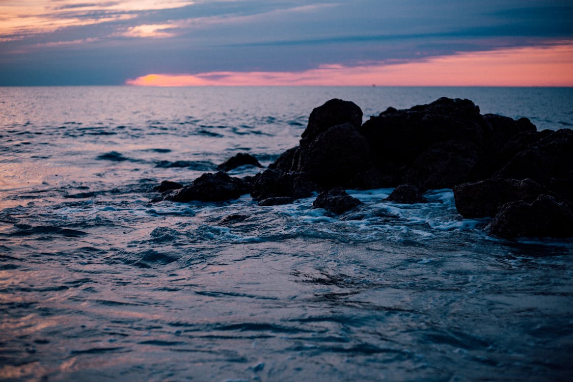免費 太陽落山時的岩石海岸 圖庫相片