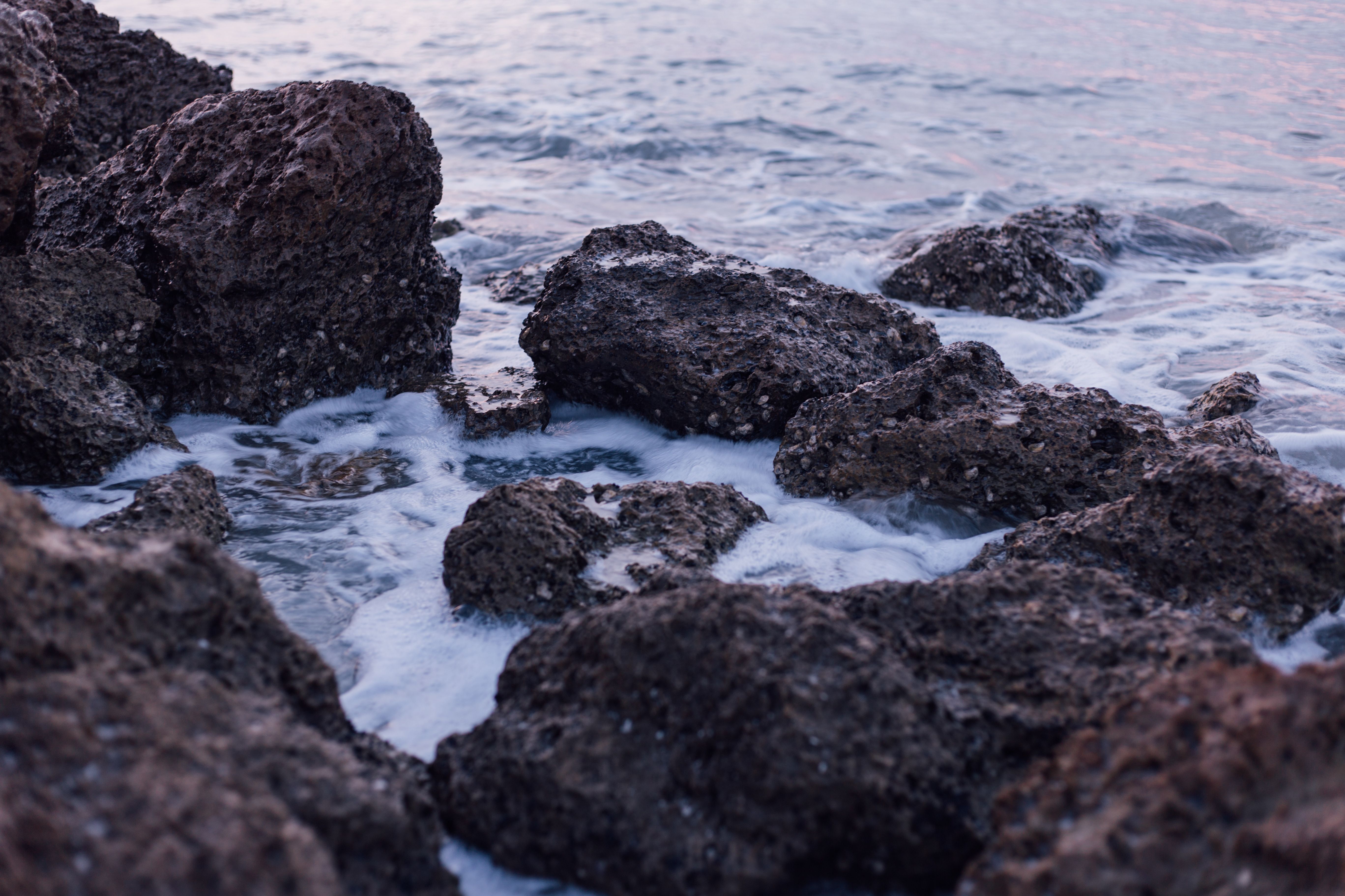 Black and Brown Rocks on Sea during Daylight · Free Stock Photo