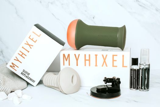 Green and White Ceramic Mug Beside White and Black Headphones