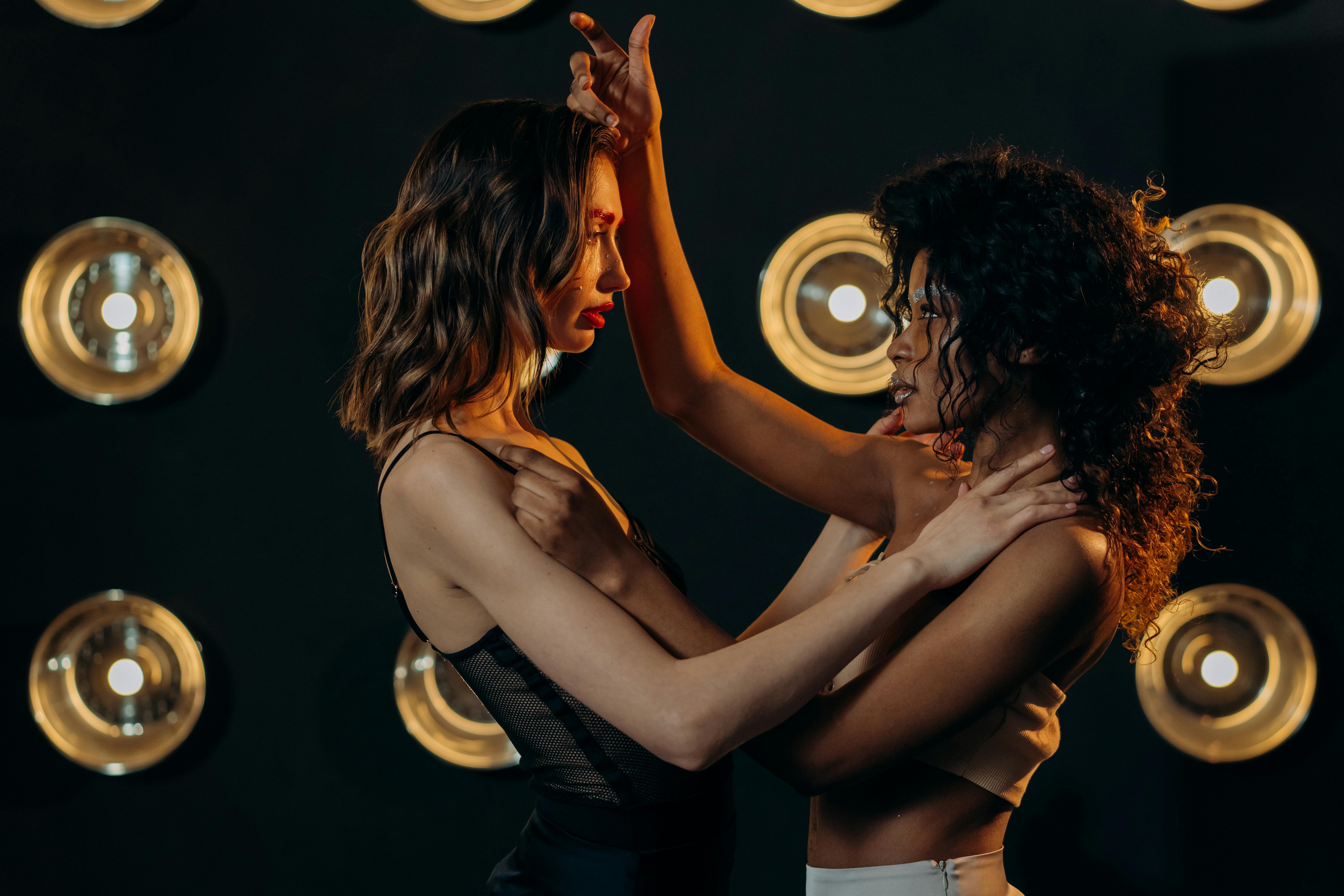 woman in black tank top and black shorts kissing woman in black tank top