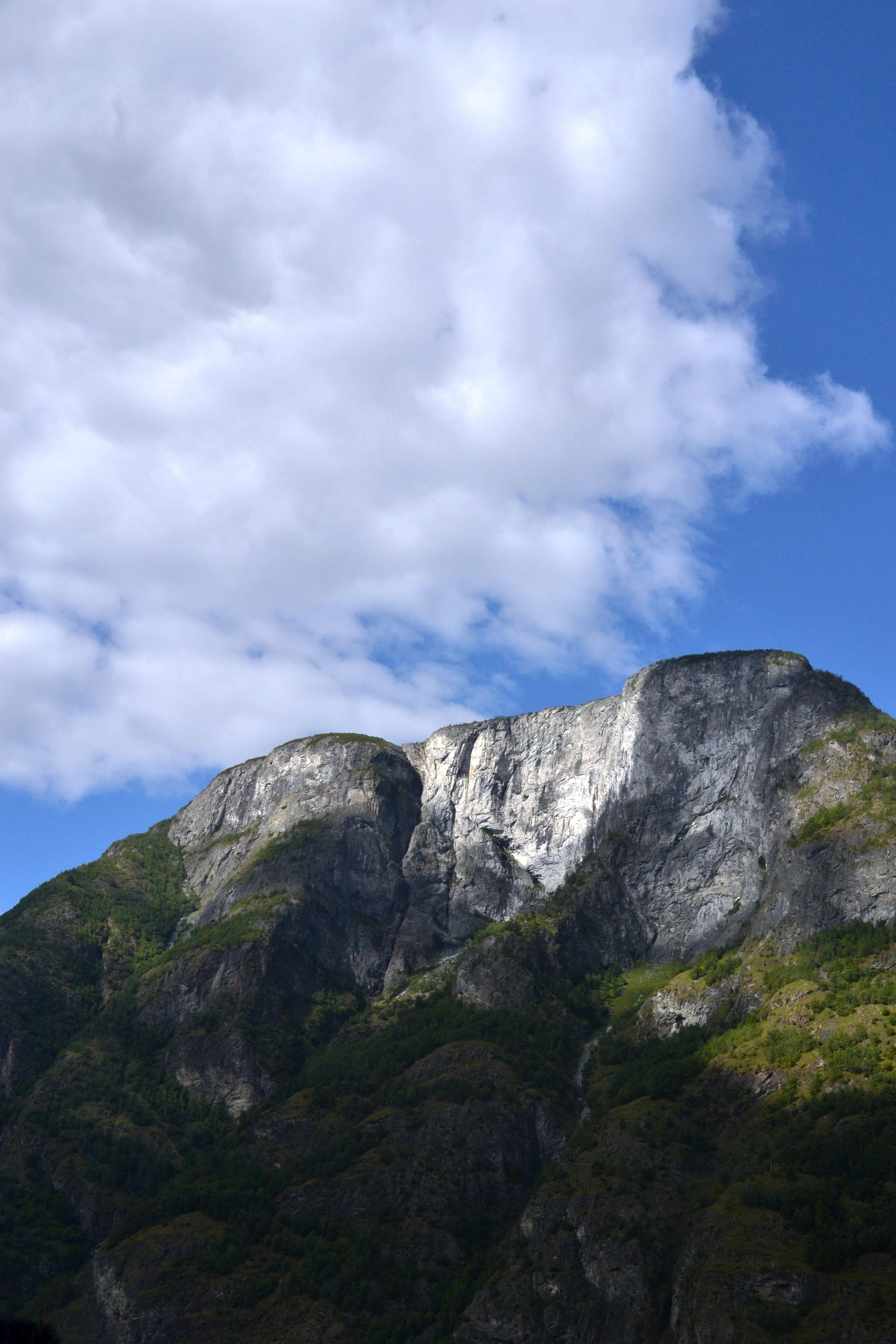 A Rocky Mountain Under White Clouds With Blue Sky · Free Stock Photo
