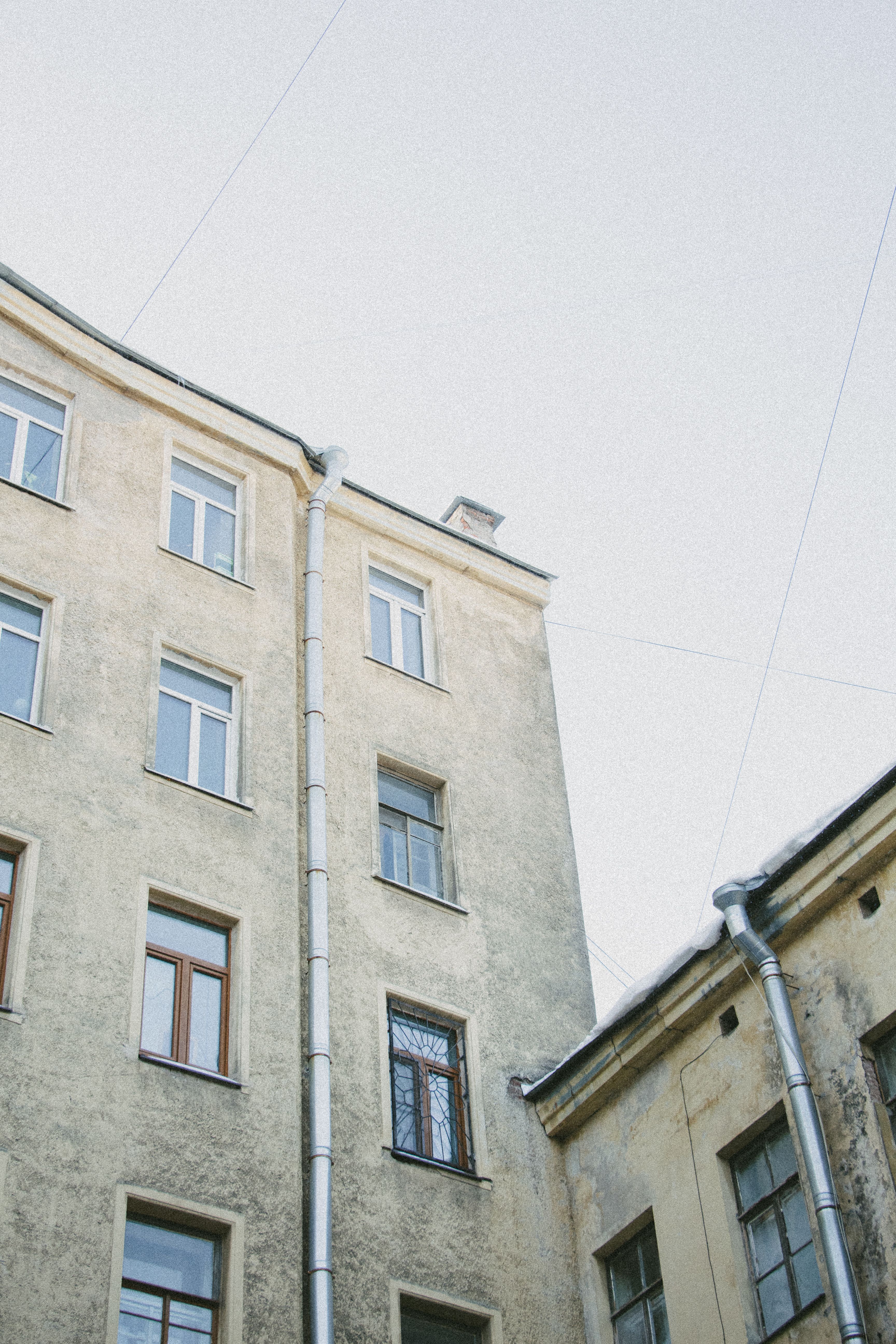 Low Angle Shot of Concrete Buildings Under the White Sky · Free Stock Photo