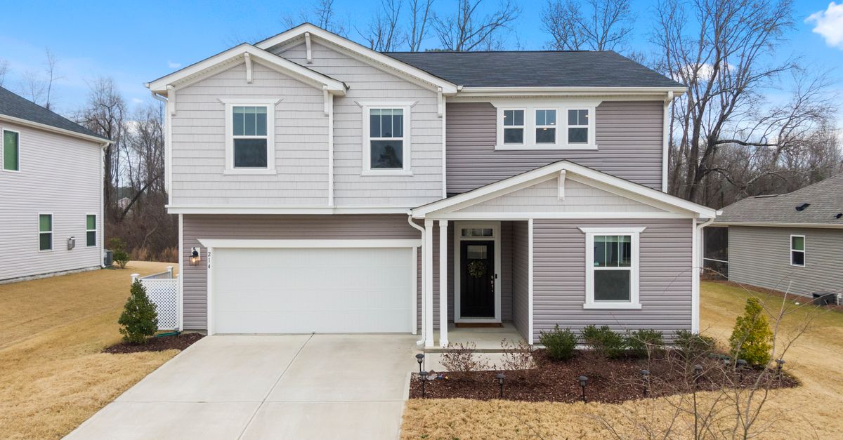 A modern suburban house with a front lawn and garage in Fuquay-Varina, NC.