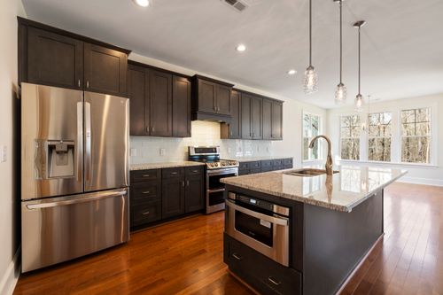 Free Bright and spacious kitchen featuring stainless steel appliances and a large island. Stock Photo