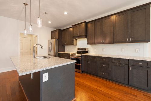 Free Spacious modern kitchen featuring a granite island, stainless steel appliances, and hardwood floors. Stock Photo