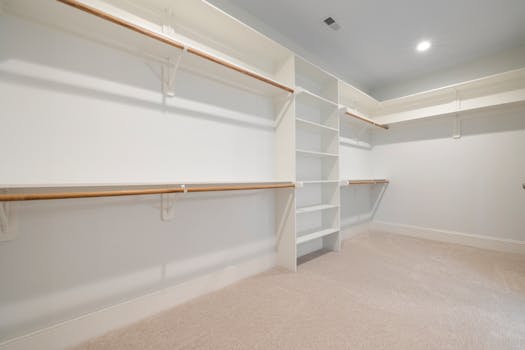 Modern empty walk-in closet with ample shelves and hanging rods for storage.
