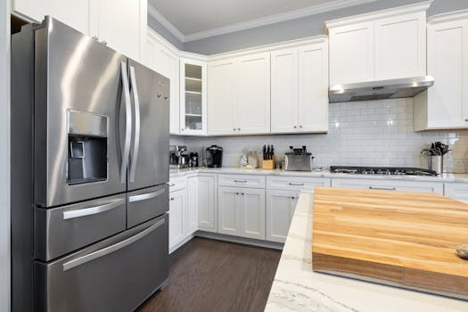 Spacious modern kitchen featuring stainless steel appliances and white cabinets, perfect for culinary enthusiasts.