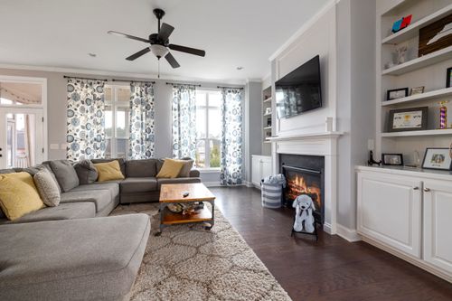 Free A spacious living room featuring a cozy fireplace, modern sofa, and elegant decor with natural light. Stock Photo
