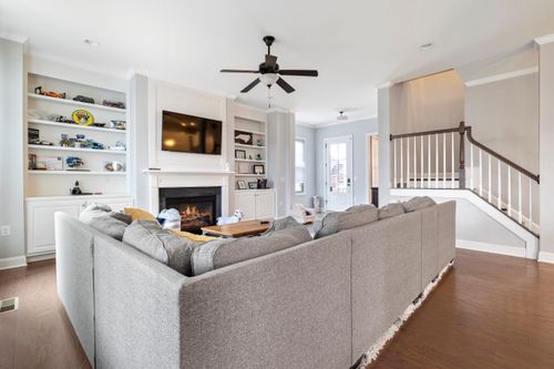Free Spacious modern living room with a cozy gray sectional, fireplace, and open shelving. Stock Photo
