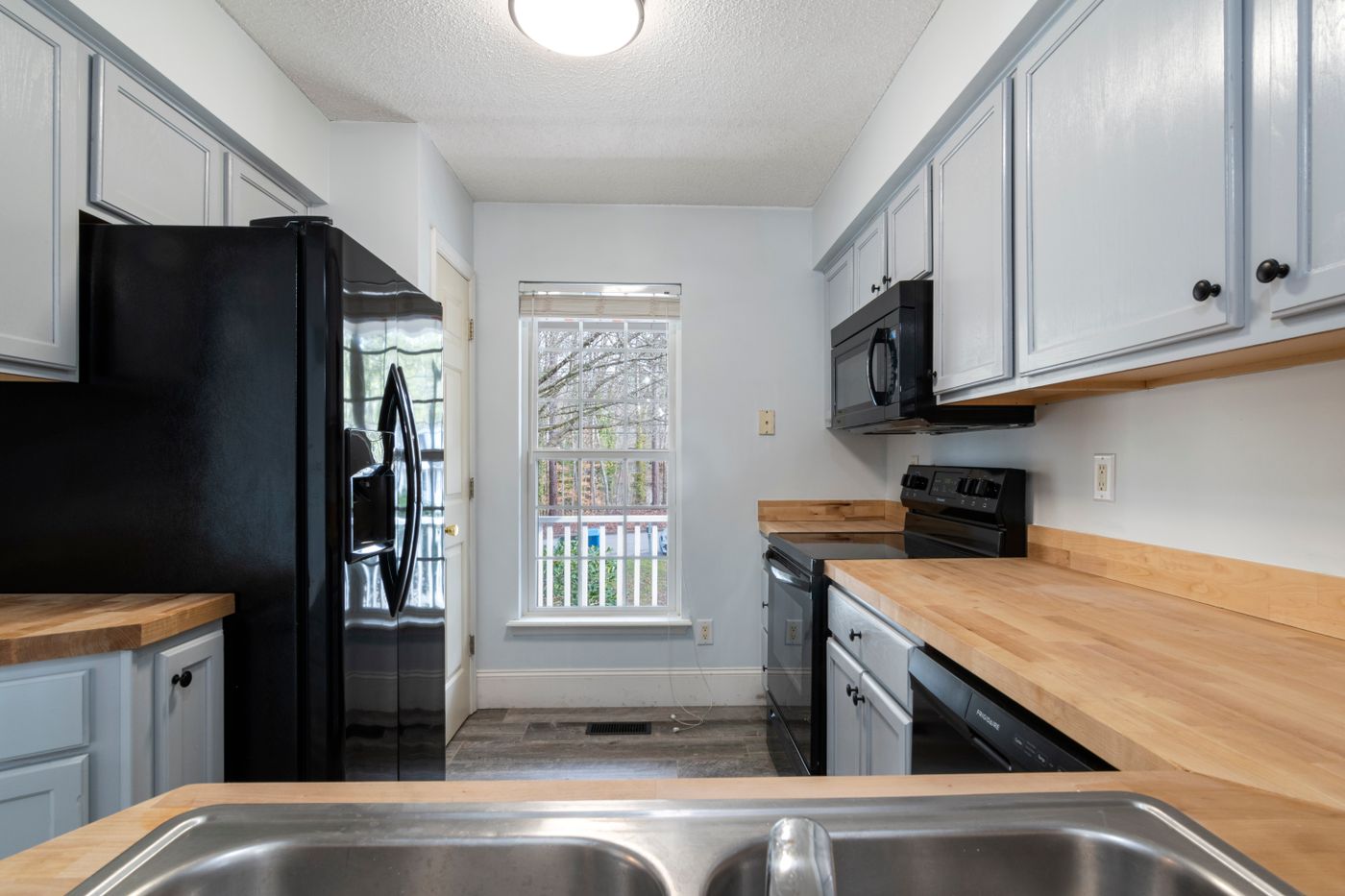 Bright modern kitchen with wooden countertops and stainless steel appliances
