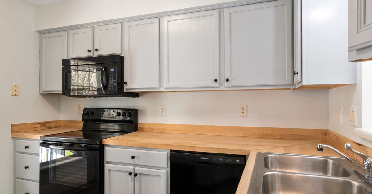 A modern kitchen featuring stainless steel sink and appliances with minimalist design.