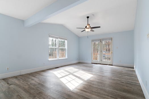 Modern empty room with blue walls and ceiling fan, ideal for interior design inspiration.