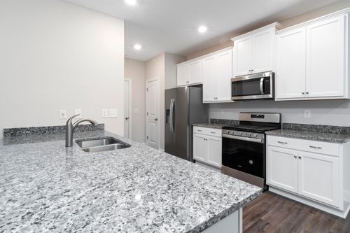 Free Clean modern kitchen design featuring granite countertops and stainless steel appliances. Stock Photo