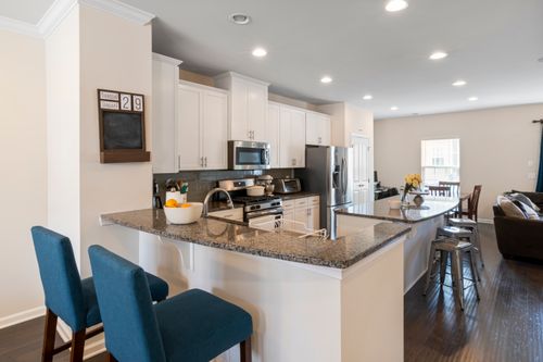 Free Bright and spacious modern kitchen showcasing granite countertops and stylish seating. Stock Photo