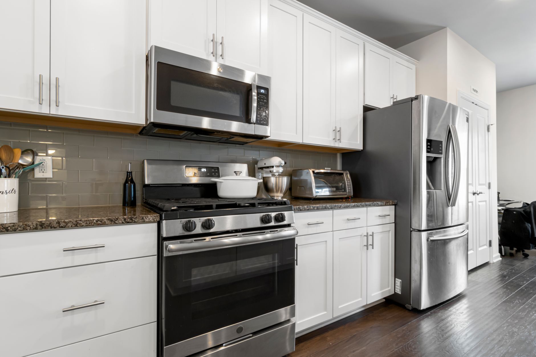 Sleek kitchen featuring contemporary white cabinets and stainless steel appliances.