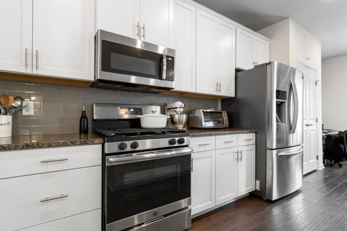 Free Sleek kitchen featuring contemporary white cabinets and stainless steel appliances. Stock Photo