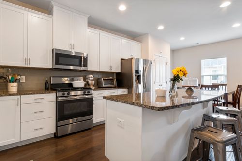 Free Stylish modern kitchen featuring a central island, stainless steel appliances, and white cabinetry. Stock Photo