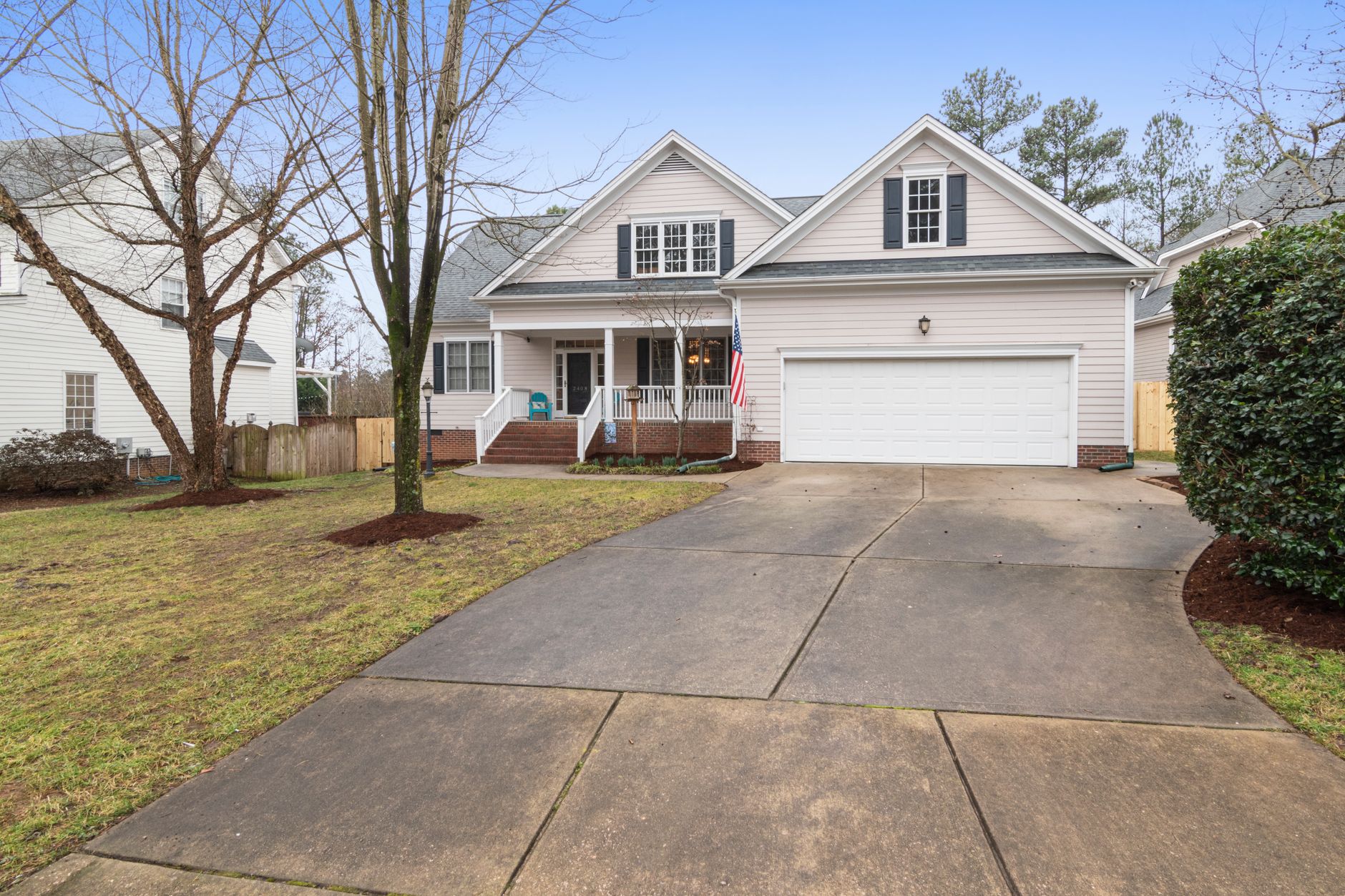 A well-maintained suburban house exterior with a large driveway, perfect for real estate listings.