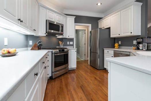 Bright kitchen with white cabinets and stainless appliances, ideal for home design inspiration.