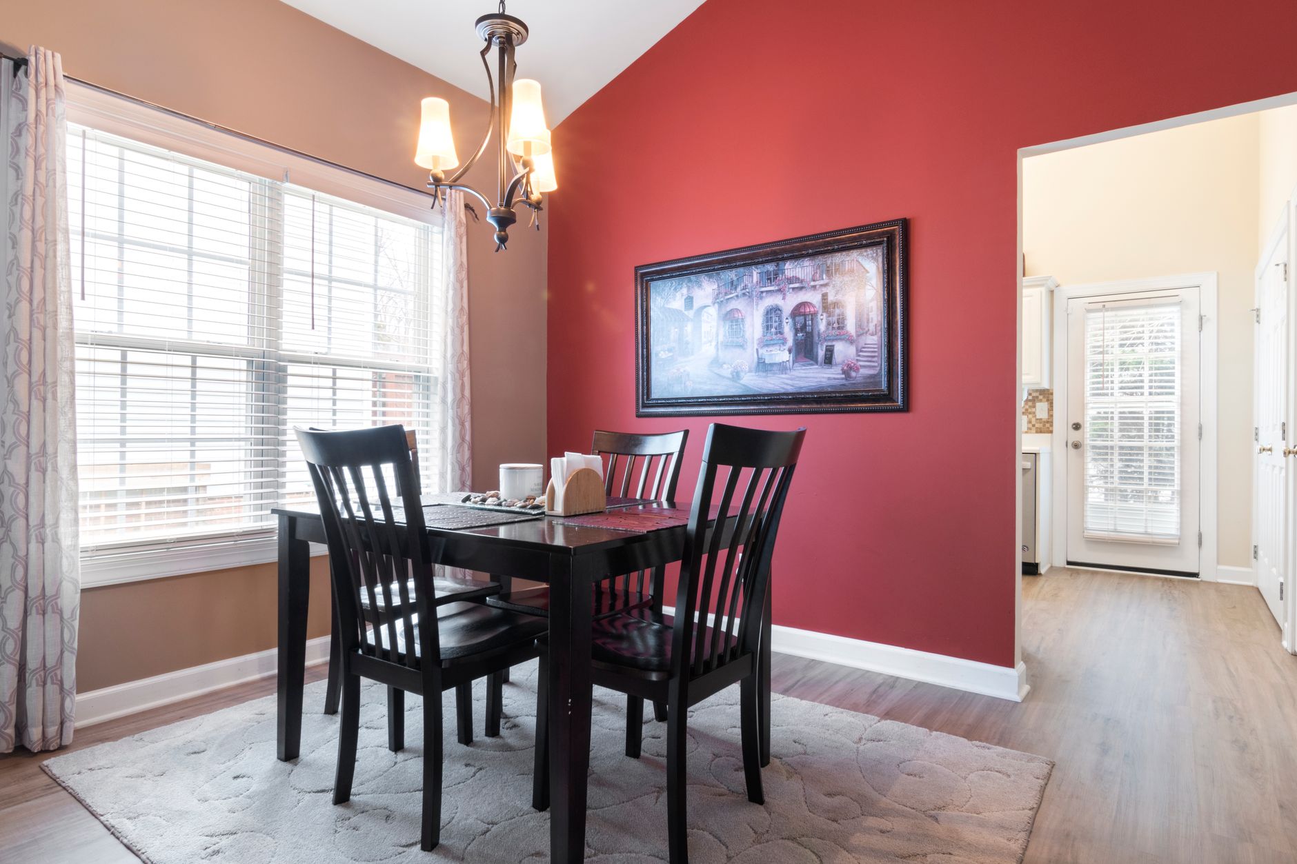 Cost to Paint an Accent Wall in Minneapolis in 2026 (What Homeowners Really Pay) 2 A stylish dining area featuring a red accent wall, black furniture, and modern decor.