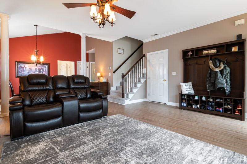 Spacious living area with leather couches and chandelier